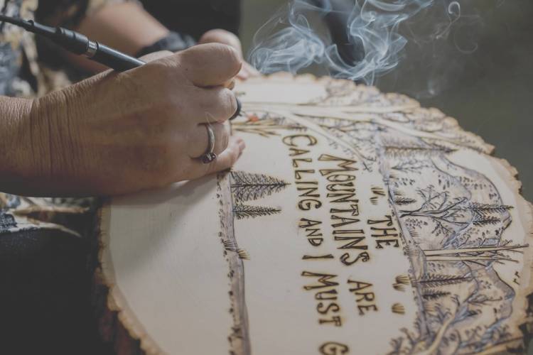 Man doing wood burning art. 